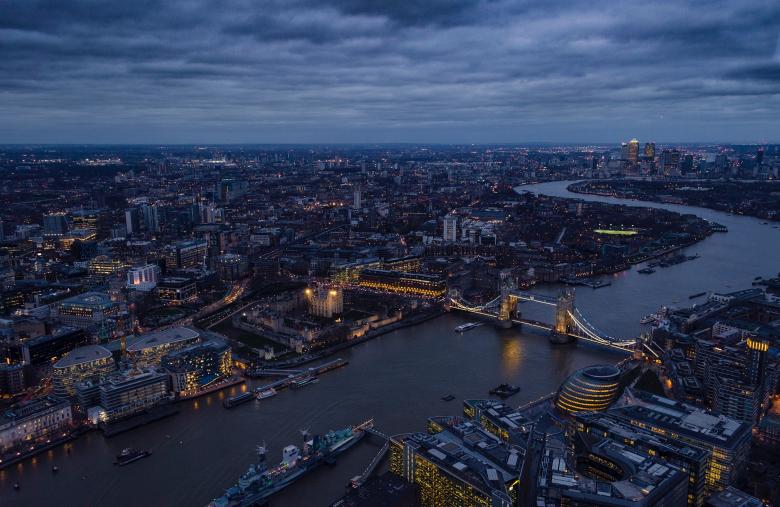 Aerial view of London at dusk, with Tower Bridge in the distance